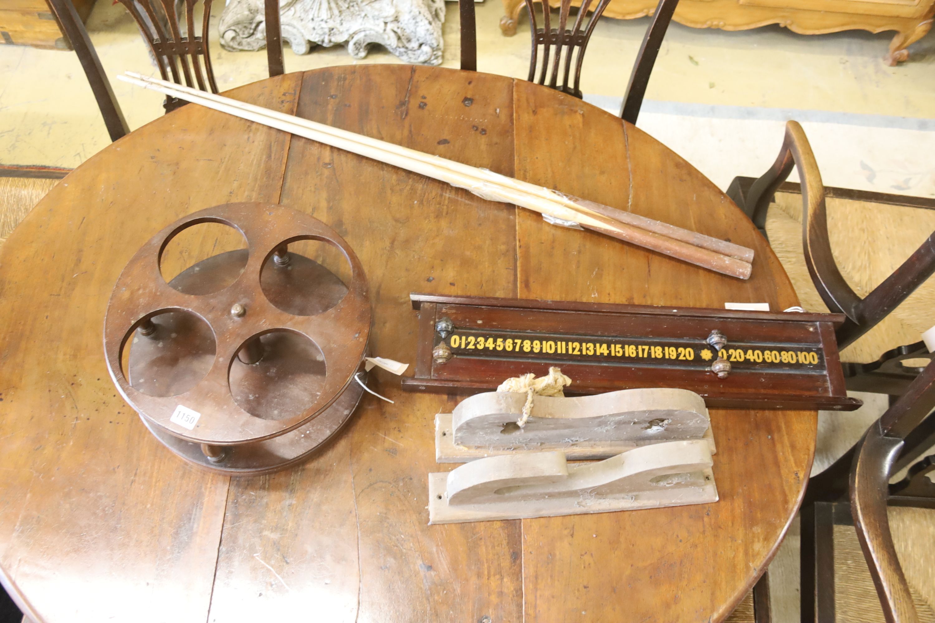 A mahogany bottle frame and a billiards scoreboard, cues and rack